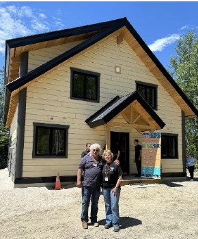 two people standing in front of a home